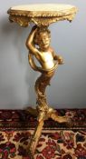 A 19th century carved giltwood torchere The column formed as a double dragon tailed putto,