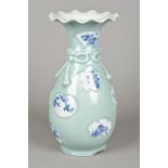 A Japanese porcelain celadon ground vase With bow tied neck and blue and white painted shaped