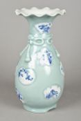 A Japanese porcelain celadon ground vase With bow tied neck and blue and white painted shaped