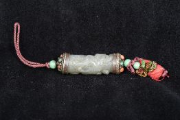 A Tibetan unmarked white metal mounted carved jade pendant Of cylindrical form,