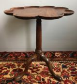 A George III mahogany tripod table The dished shaped top above the turned column,