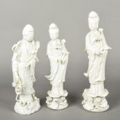 Three Chinese blanc de chine porcelain figures of Guanyin All modelled in flowing robes holding