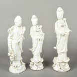 Three Chinese blanc de chine porcelain figures of Guanyin All modelled in flowing robes holding