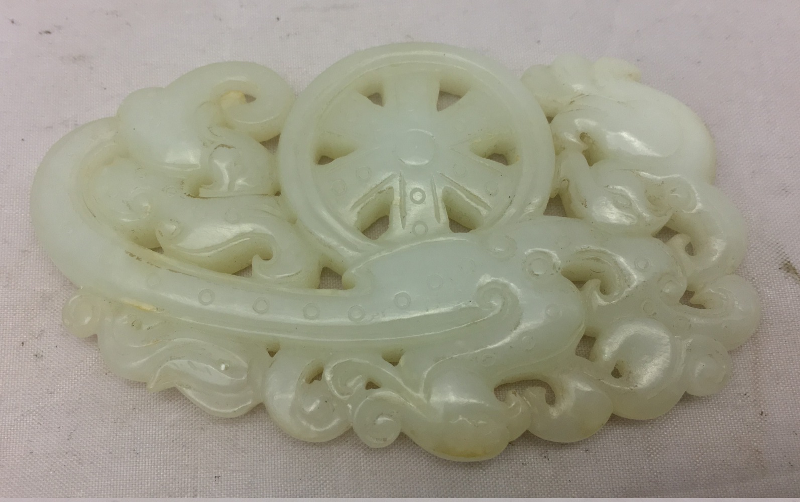 A Chinese carved celadon jade group Worked with stylised phoenixes flanking a spoked wheel. 8. - Image 3 of 4