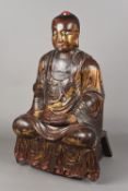 An 18th century or earlier carved wood gilt decorated and lacquered figure of Buddha Modelled in