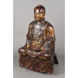 An 18th century or earlier carved wood gilt decorated and lacquered figure of Buddha Modelled in