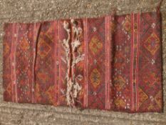 A Caucasian wool saddle bag rug Decorated with latch hook lozenges. 124 x 67 cm.