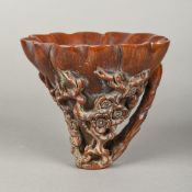 A carved horn libation cup Typically carved with floral and bamboo sprays,