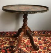 An unusual tripod table The dished circular top inset with early 20th century postage stamps,
