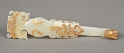 A Chinese mutton fat jade belt hook Of scrolling form with mask finial and gilt decorations.