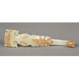 A Chinese mutton fat jade belt hook Of scrolling form with mask finial and gilt decorations.