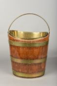 A brass bound oak coal bucket Of oval form with brass swing handle and brass interior lining.