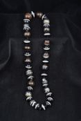 A banded agate bead necklace The beads of differing sizes. Approximately 64 cm long.