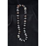 A banded agate bead necklace The beads of differing sizes. Approximately 64 cm long.