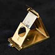 An 18 ct gold folding cigar cutter Set with a cabochon sapphire clasp, with suspension loop. 3.