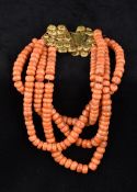 A four strand coral bead necklace Set with an unmarked gold filigree clasp. 29 cm long.