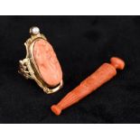 A 10K gold coral and seed pearl mounted ring Carved with a head of a young lady;