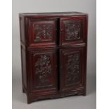 A 19th/20th century Chinese carved hardwood table cabinet The two pairs of panelled doors worked