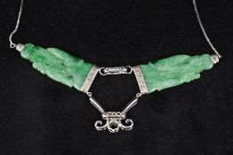 An 18 ct white gold and jade necklace Set with two carved jade deities. 51 cm long.