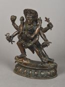 An Eastern patinated bronze model of a four armed deity Modelled holding a woman in a headdress,