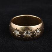 An unmarked gold and diamond gypsy set ring Of typical form set with three diamonds,