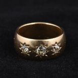 An unmarked gold and diamond gypsy set ring Of typical form set with three diamonds,