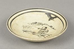 A Chinese Cizhou footed porcelain dish Slip decorated with a fisherman in a mountainous landscape