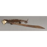 A Dayak Mandau sword Of typical form with carved bone handle issuing hair plaits,