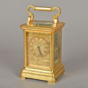 A gilt bronze cased repeat carriage clock With scroll cast handle and etched glass panels,