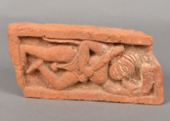 An antique Indian red pottery brick Relief moulded with a male figure blowing a horn. 24 cm wide.