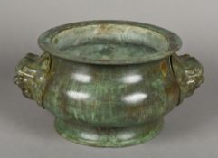 An Oriental patinated bronze censor Of squat flared circular form, with twin mask handles,