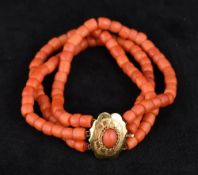 A three strand coral bead bracelet Set with a coral cabochon mounted clasp.
