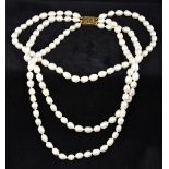 A three strand baroque pearl necklace Mounted with a 15 ct gold clasp. 43 cm long.