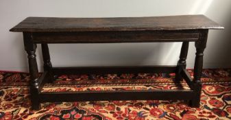 An 18th century oak bench The moulded rectangular top above the line carved frieze,