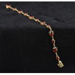 A 9 ct gold garnet set bracelet Each stone in a pierced scrolling setting. 17.5 cm long.