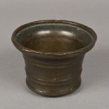 An 18th century or earlier bronze mortar The flared rim above moulded bands. 8.5 cm high.