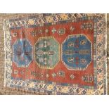 A Caucasian wool rug The tan field enclosing three medallions within rosettes and boteh,