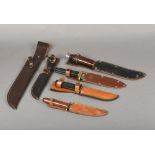 Four various bowie knives All with leather sheaths; together with two vacant leather sheaths.