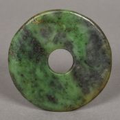 A Chinese carved green jade bi disc 10 cm diameter.