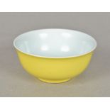 A Chinese porcelain bowl The exterior decorated with a plain yellow ground,