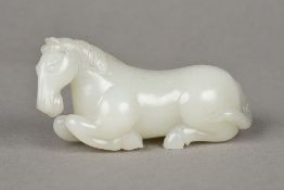 A Chinese carved celadon jade stallion Modelled recumbent. 9 cm long.