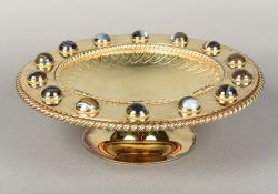 A Victorian gilt metal tazza With engraved decoration, the rim set with striped agate cabochons.