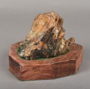 An antique mammoth's tooth Of typical form, standing on a wooden plinth base. 11.5 cm long.
