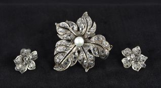 An unmarked pearl centred pierced floral brooch Set with rose cut stones;