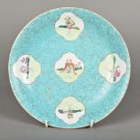 A Chinese porcelain dish Decorated with European figural vignettes on a simulated hardstone