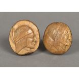 Two carved coquilla nuts Each decorated with a Red Indian bust. The largest 6.5 cm high.