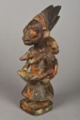 An African tribal figure, possibly Yoruba Formed as a female figure carrying a child on her back,