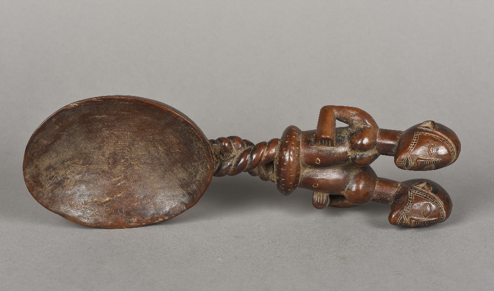 An unusual tribal carved wooden spoon The handle carved as entwined male and female figures with