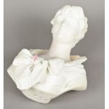 A white marble bust Carved as a young woman wearing a bow tied dress,