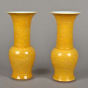 A pair of Chinese porcelain yellow ground vases Each flared rim above the elongated neck and
